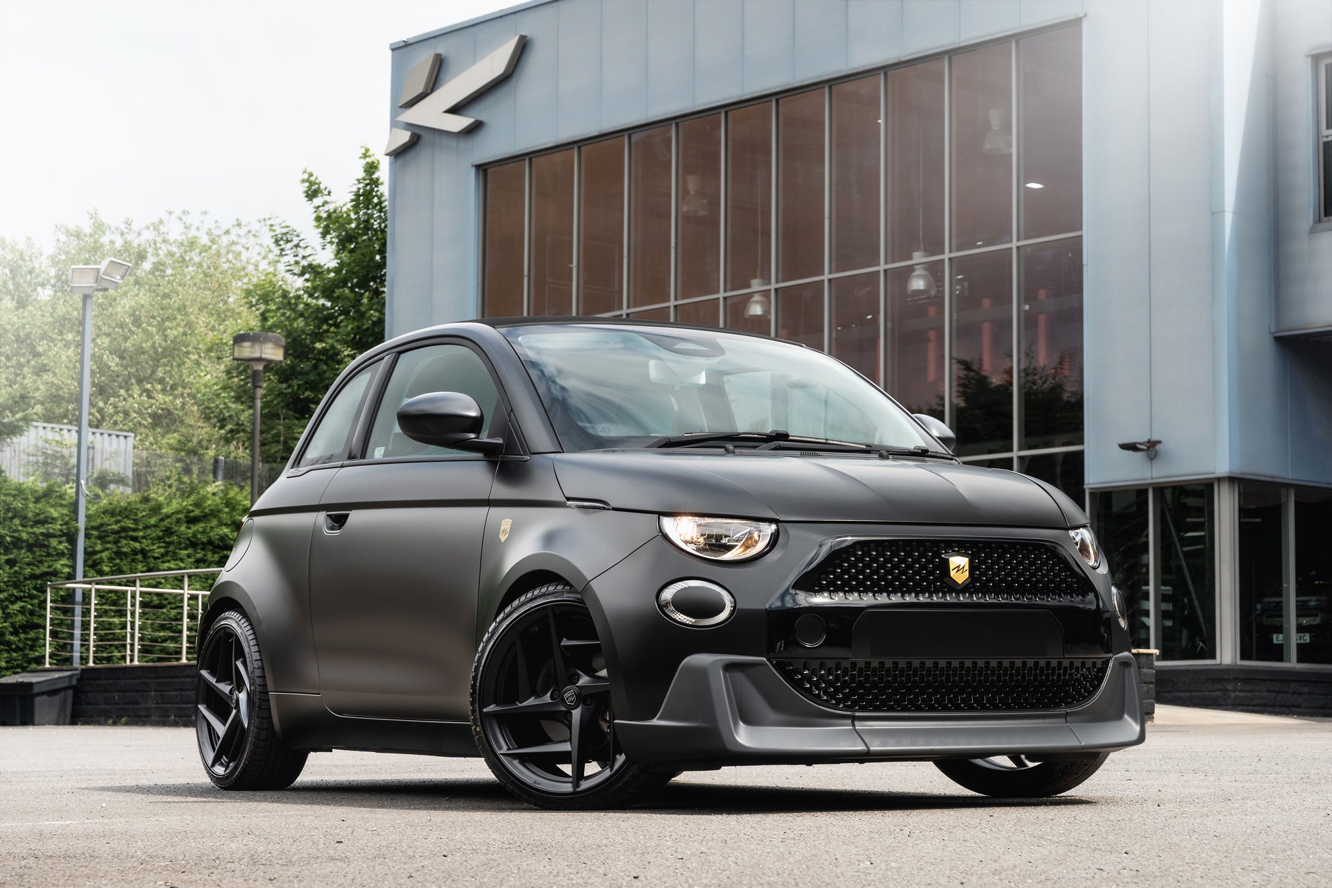 Designio Fiat 500e in Satin Black — front three-quarter view outside the KAHN Design studio