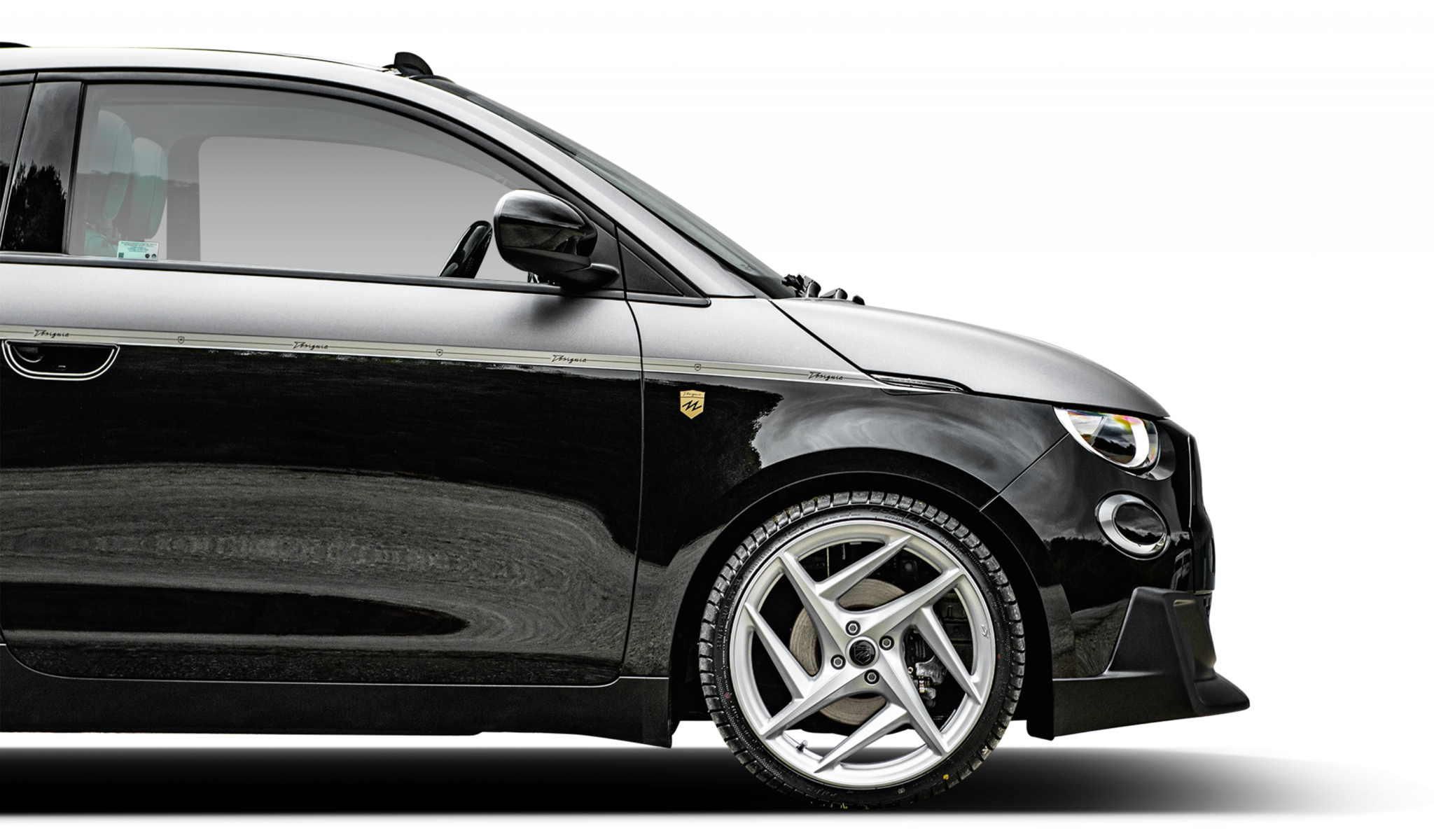 Black Fiat 500e by Designio, front quarter in focus.